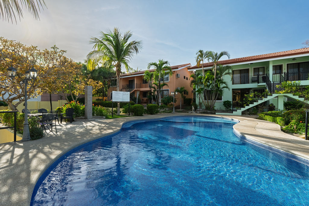 The blue community pool with houses behind